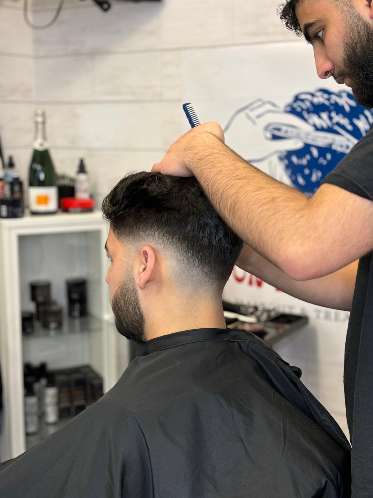 Naor cutting a low fade with clippers in his Saint-Laurent studio
